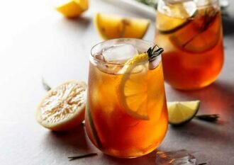 Traditional iced tea with lemon, lime and ice garnished with ros